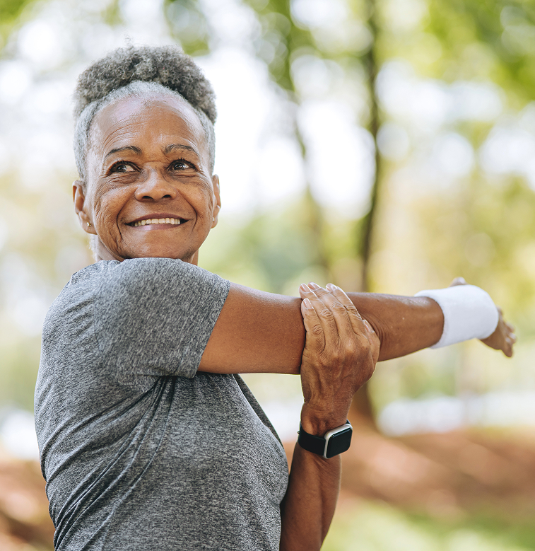 Older woman stretching outdoors, reflecting daily movement in an Ayurvedic lifestyle routine